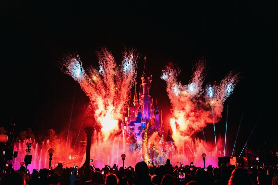 Nighttime fireworks and projections lighting up Sleeping Beauty's Castle at Disneyland Paris