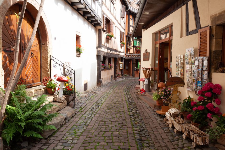 A hand-painted winegrower's sign above a timber-framed doorway in Eguisheim, Alsace