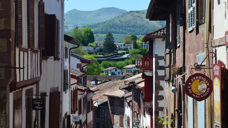 The stone fronton pelota court in the centre of Espelette with the village church behind it