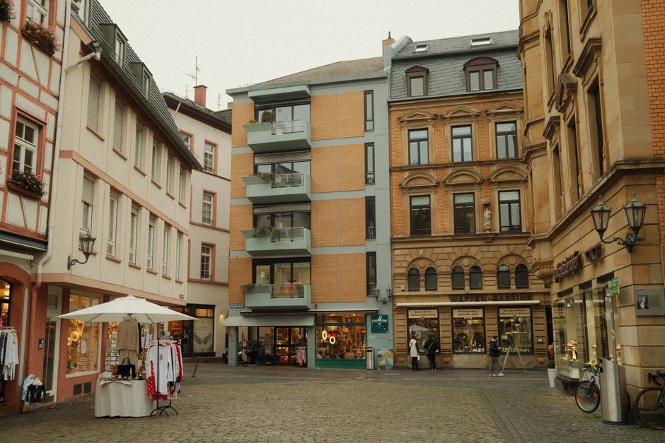 Market stalls filling the central arcaded square of Eymet on a Thursday morning, with half-timbered facades on all sides