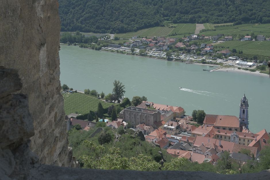 A view over Eymet's grid of red-tiled rooftops from the church tower, with the Dropt river and surrounding vineyards visible beyond