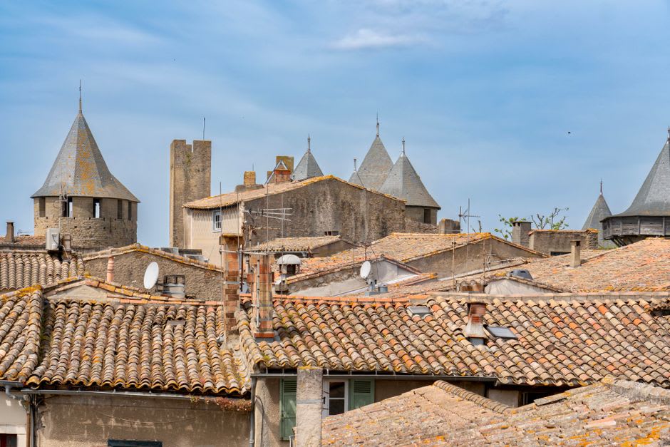 The three stone towers of Château de Foix seen from the ramparts with the old town's rooftops below