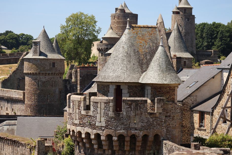 Stone ramparts and defensive towers along the walls of Château de Fougères overlooking the Nançon river
