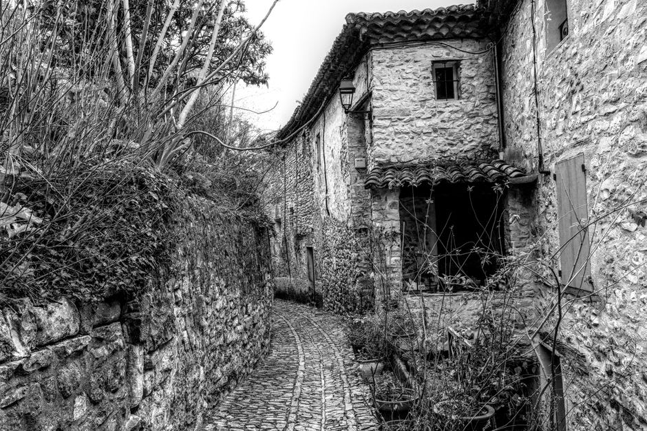 A narrow stone stairway lane climbing between pale houses in the hilltop village of Gordes