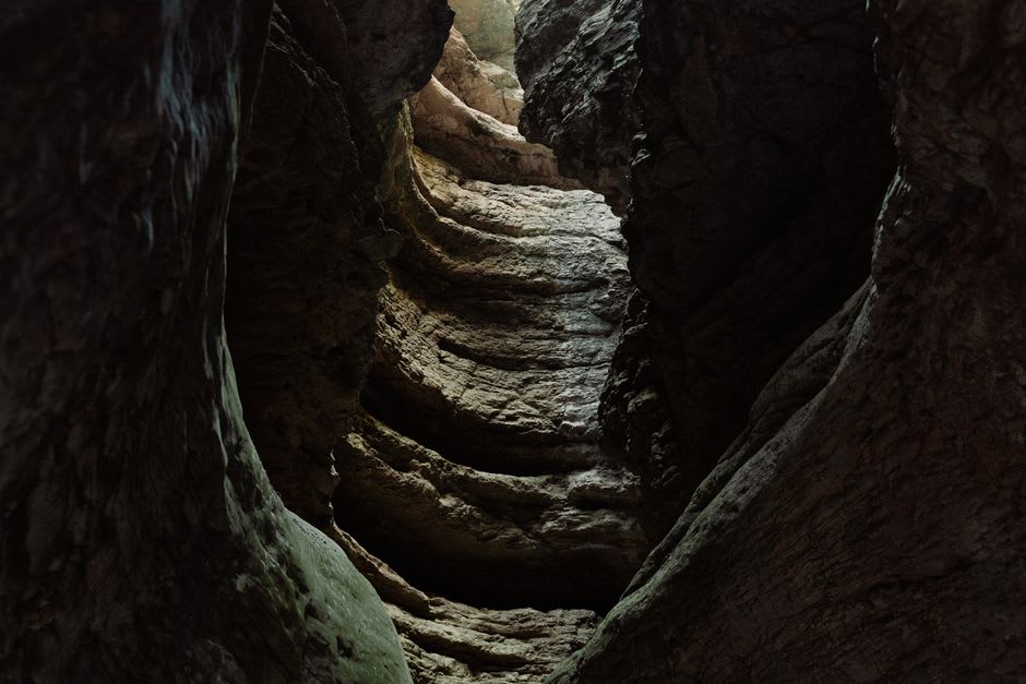 The narrow rock chasm and iron ladder descending into the Grotte du Diable near Huelgoat