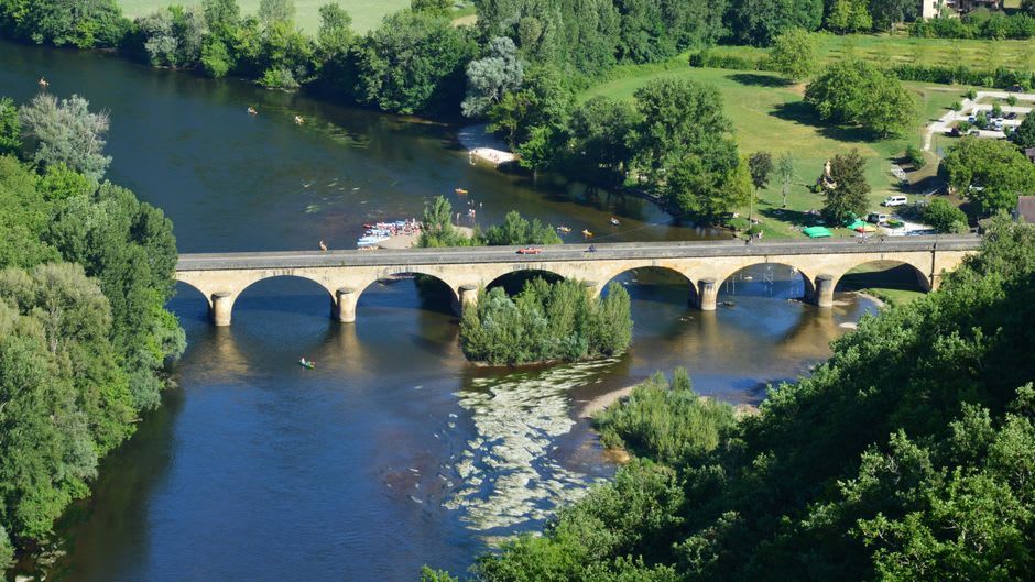 The stone lock at Lalinde with a small boat working through the gates, the calm Dordogne river visible on either side