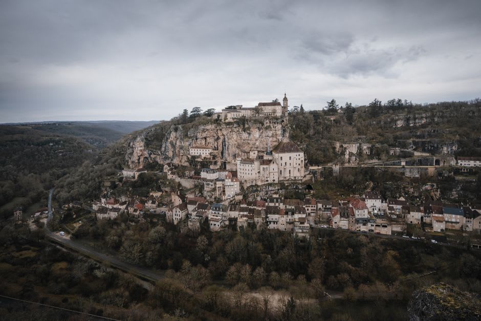 The heritage steam train of the Train du Haut Quercy running along the cliffside track above the Dordogne gorge