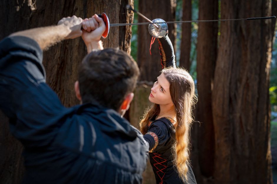 Costumed medieval reenactors staging a swordfight on the grounds of Château de Murol