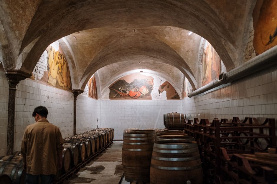 Vaulted stone cellar in Nuits-Saint-Georges lined with oak barrels of ageing Pinot Noir