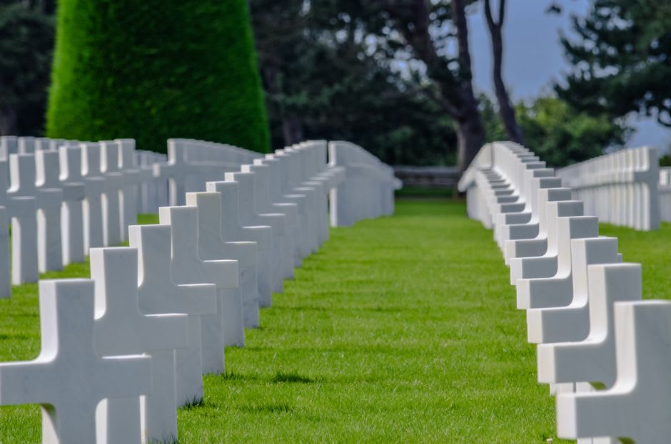Rows of white marble crosses at the Normandy American Cemetery overlooking Omaha Beach from the bluff