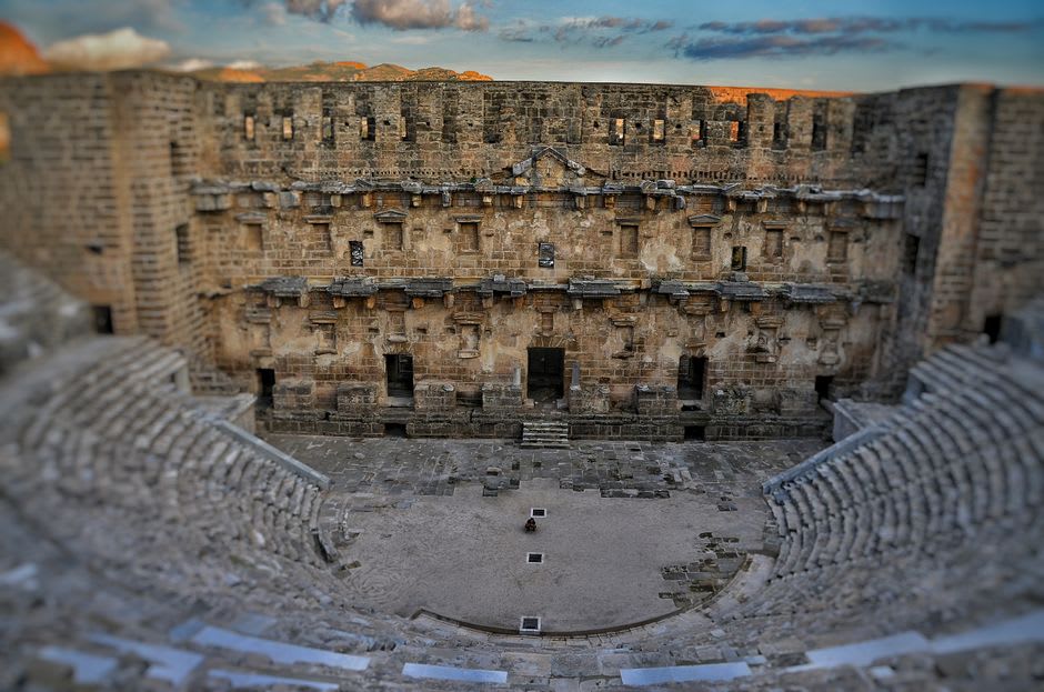 The upper tier of ancient stone seating inside the Roman Theatre of Orange, looking down toward the towering stage wall