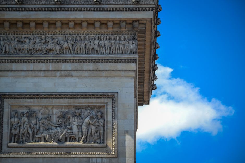 The weathered triumphal Arc de Triomphe of Orange standing on a roundabout with its carved battle reliefs visible