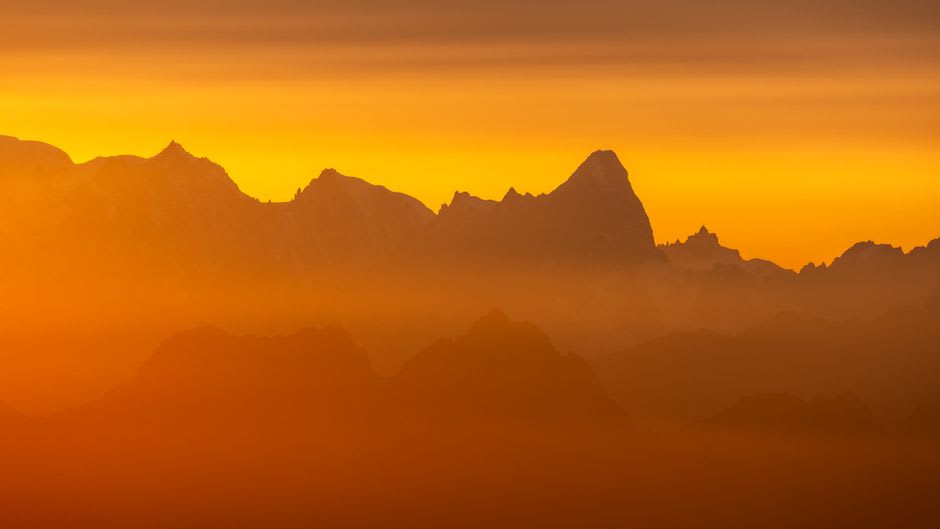 The long terrace of the Boulevard des Pyrénées with mountain peaks lining the horizon at sunset