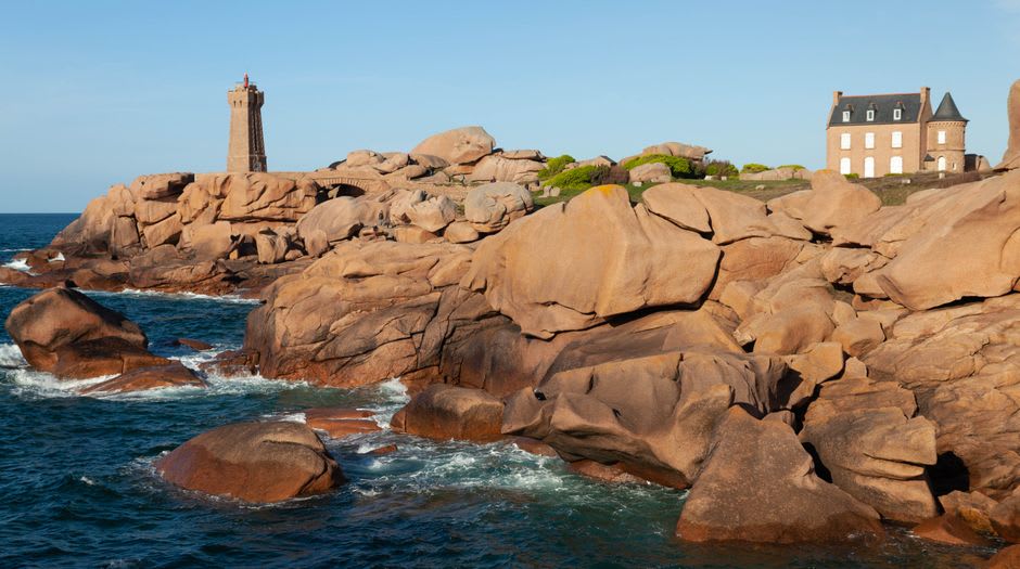 The pink-hued granite lighthouse at Ploumanac'h rising among huge rounded boulders on the coastal path