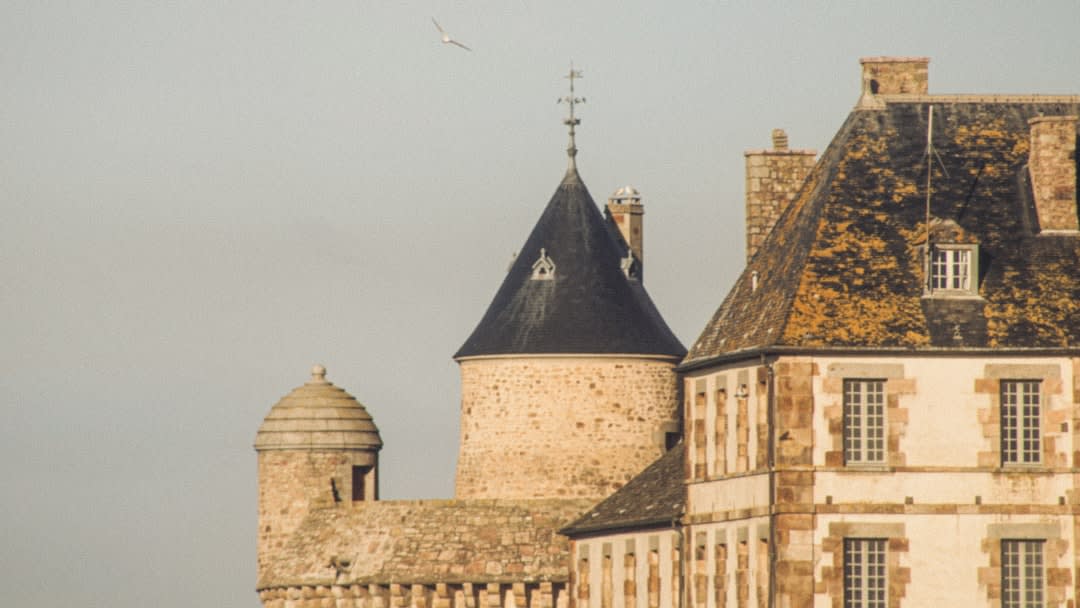 The round medieval tower and moat of the Château de Rambouillet with formal gardens in front