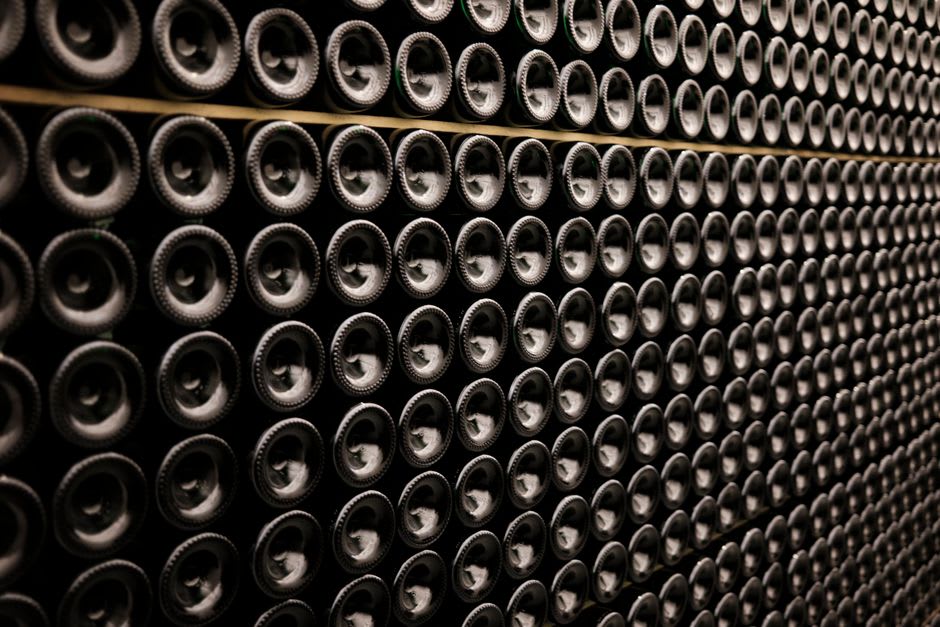 Rows of champagne bottles aging at an angle in the chalk cellars beneath one of Reims's grand champagne houses