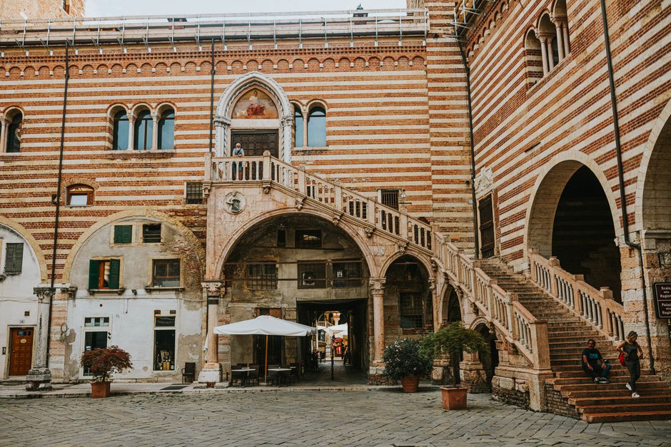 A hidden Renaissance courtyard with a carved stone spiral staircase behind a plain street facade in Riom