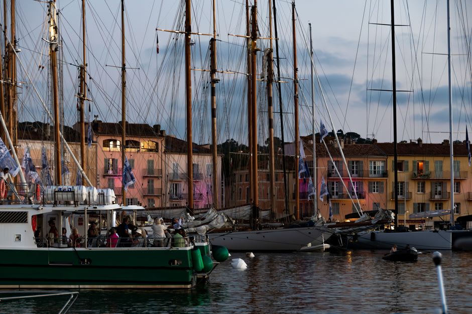 Superyachts moored stern-to along the pastel-coloured harbourfront of Saint-Tropez at golden hour