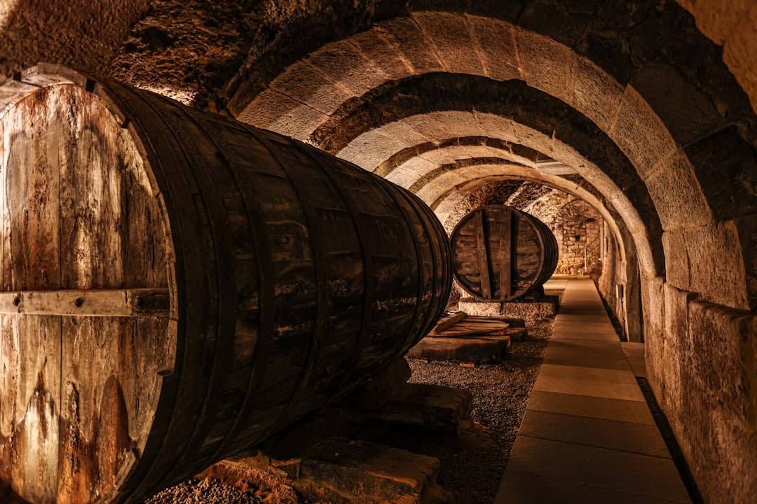 A long underground tunnel in a Saumur wine cave, walls lined with racks of sparkling wine bottles resting at an angle