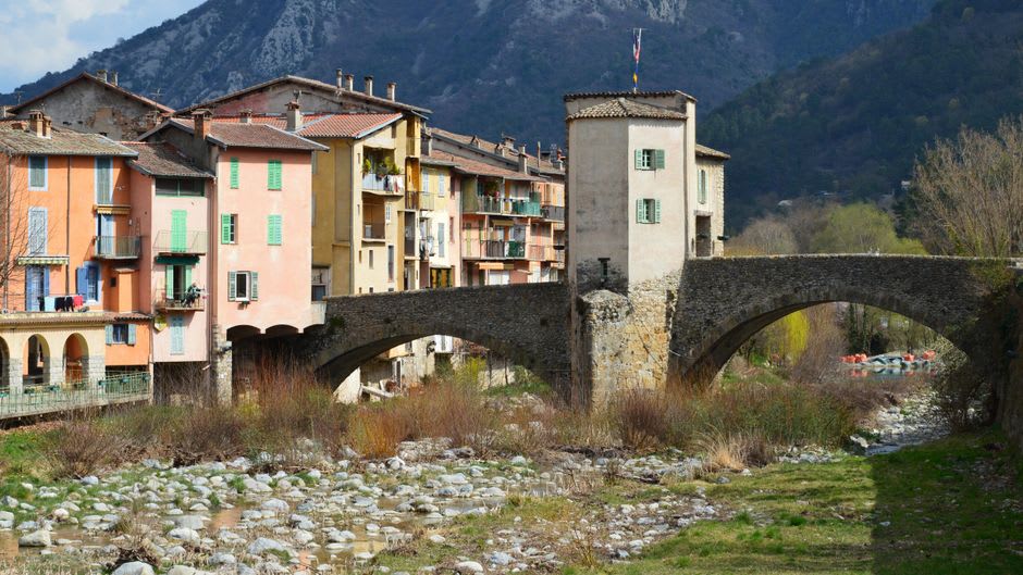 Pastel-colored arcaded houses lining the Bévéra riverbank in Sospel's old town