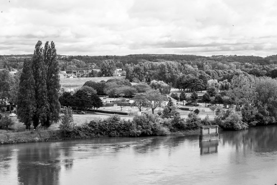 A raised grass-covered levee running along the Loire near Sully-sur-Loire with poplar trees in the distance
