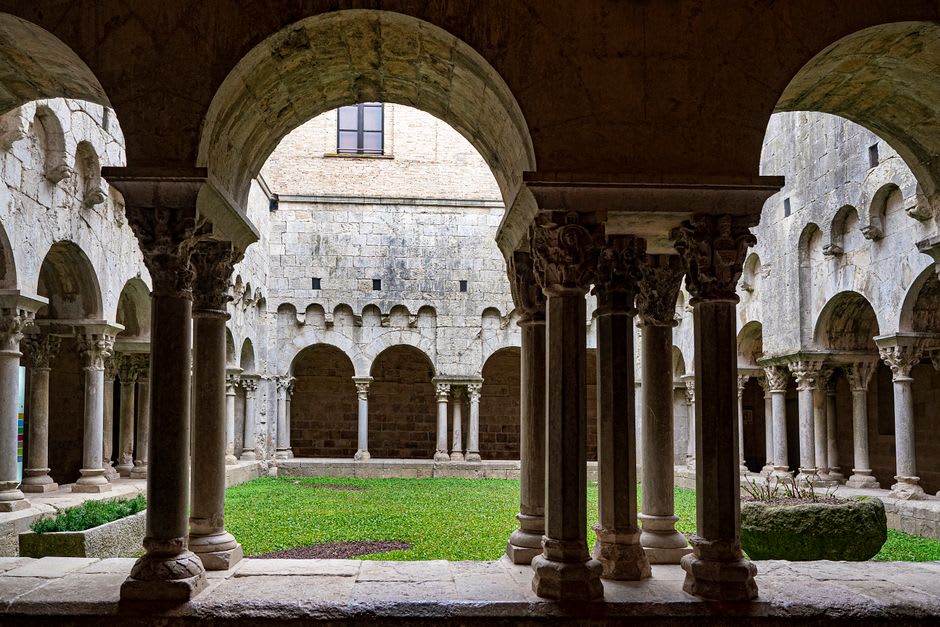 The Gothic cloister of Tréguier cathedral with stone arcades surrounding a quiet garden