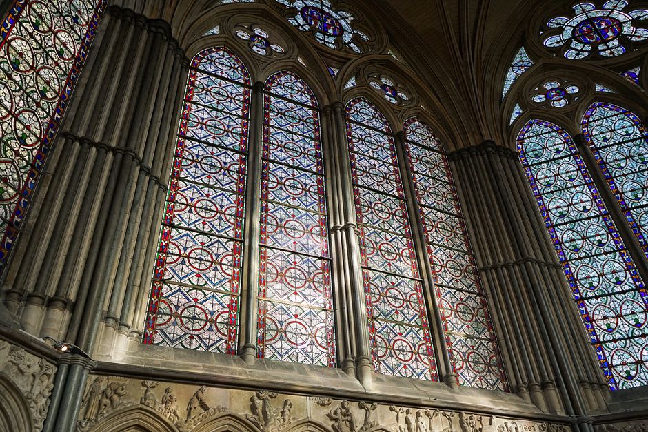 Medieval stained-glass windows inside one of Troyes's Gothic churches casting coloured light on stone columns