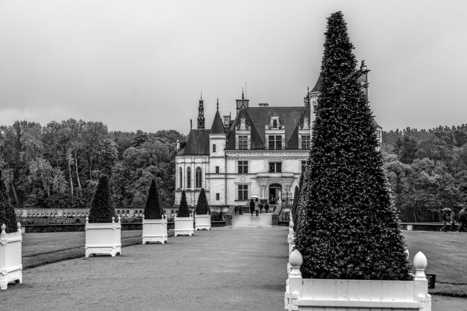 The formal terraced gardens below Château d'Ussé with clipped box hedges leading down toward the Indre river