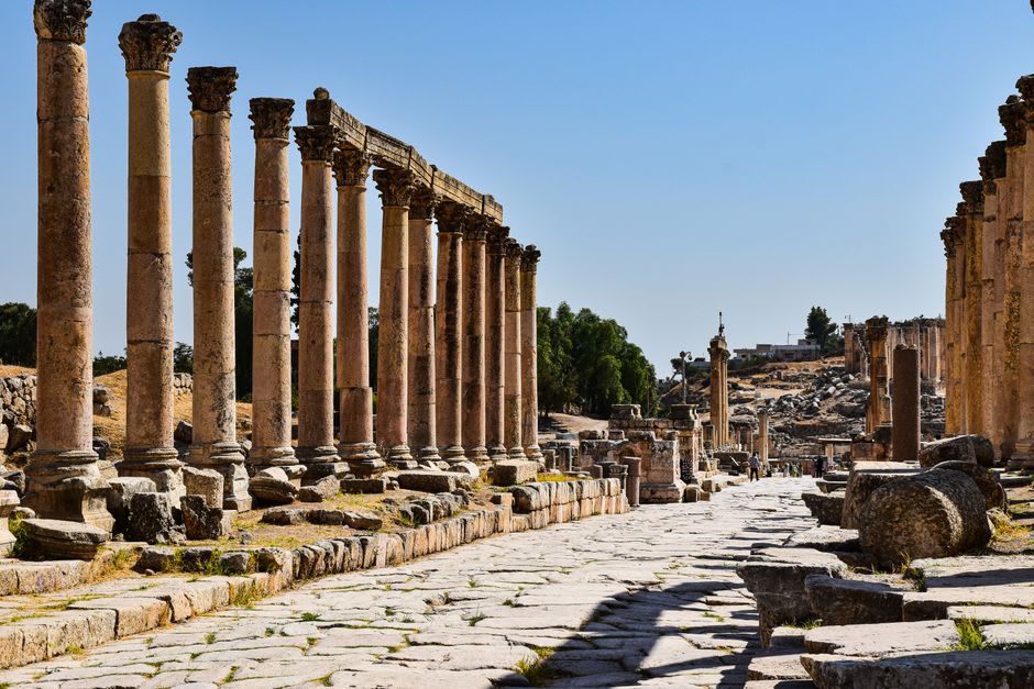 Excavated Roman ruins and colonnades of the ancient city at Vaison-la-Romaine under a clear blue sky