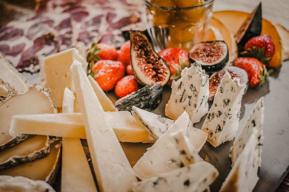 A truncated pyramid-shaped Valençay goat cheese dusted with ash, displayed on a wooden board