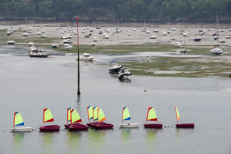 Sailboats moored in the old port channel of Vannes with the half-timbered old town rising behind