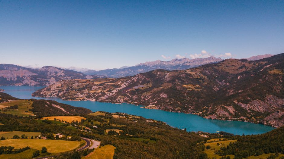 The panoramic view from the Rocher des Pendus over Vic-sur-Cère and the green Cère valley toward the Cantal peaks