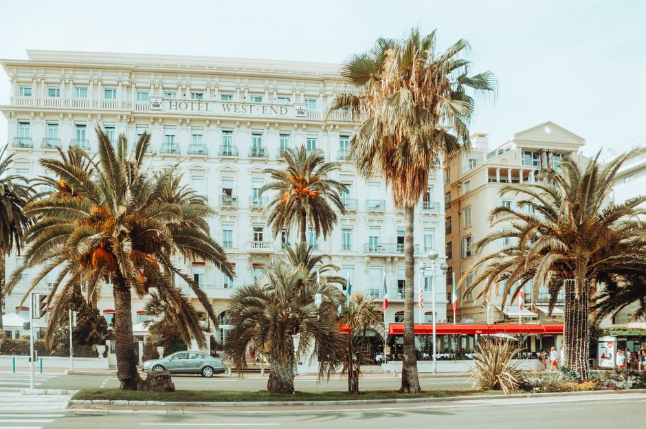 A row of grand Belle Époque hotel facades along a tree-lined street in central Vichy