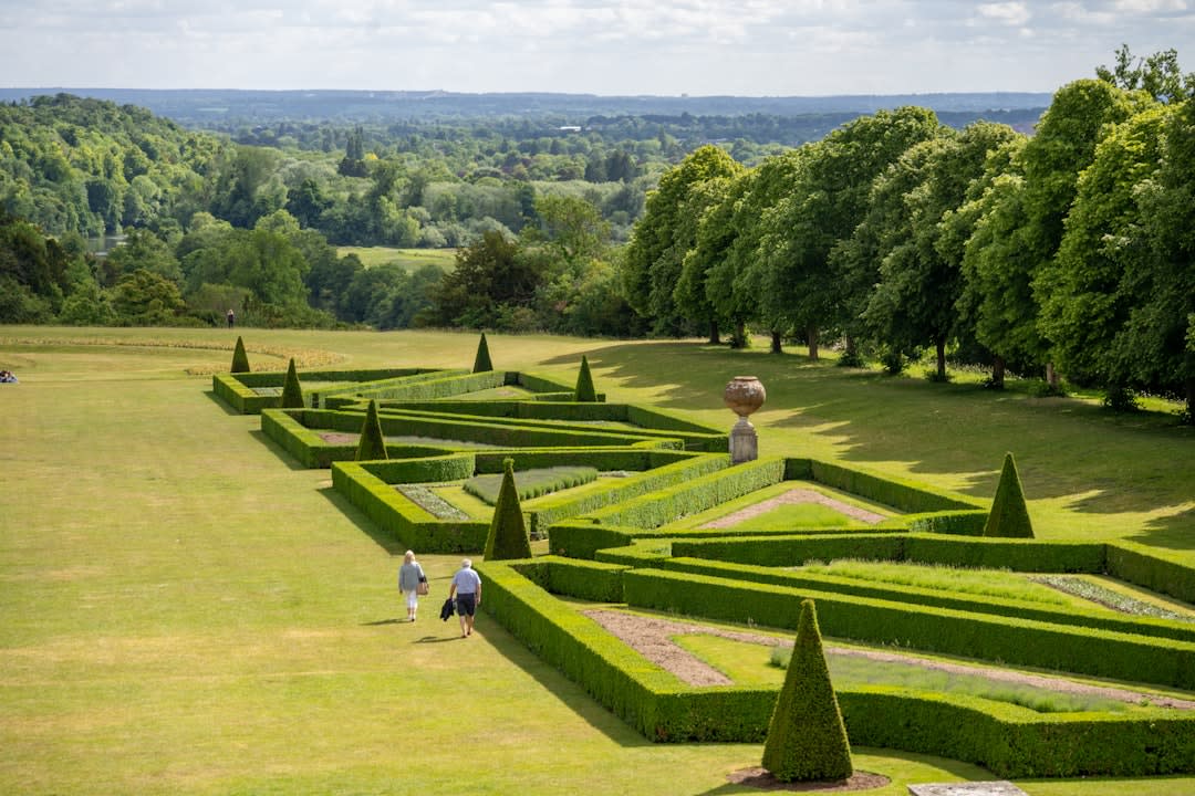 The clipped box-hedge patterns of Villandry's ornamental love garden with a gardener working among the beds