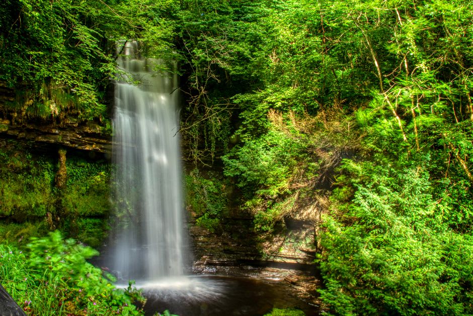 Fourgassié waterfall dropping through granite boulders surrounded by dense rainforest near Roura