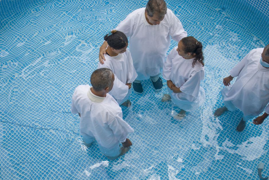 A pilgrim group in white robes gathered at the steps of the Yardenit baptismal site on the Jordan River
