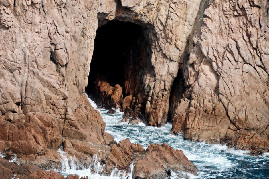 The weathered entrance to Nelson Bay Cave overlooking the ocean