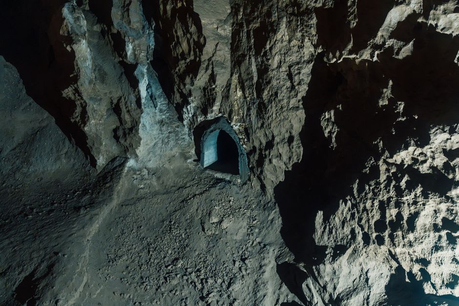 The dark entrance of the ancient water tunnel carved through rock toward the Mtkvari River