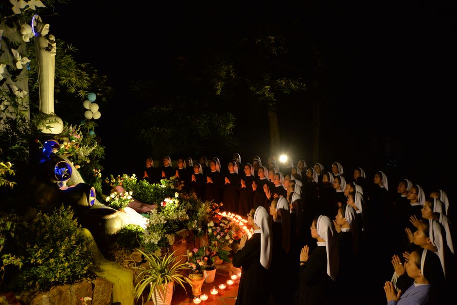 Couples lighting candles at the Holy Trinity Convent in Murom