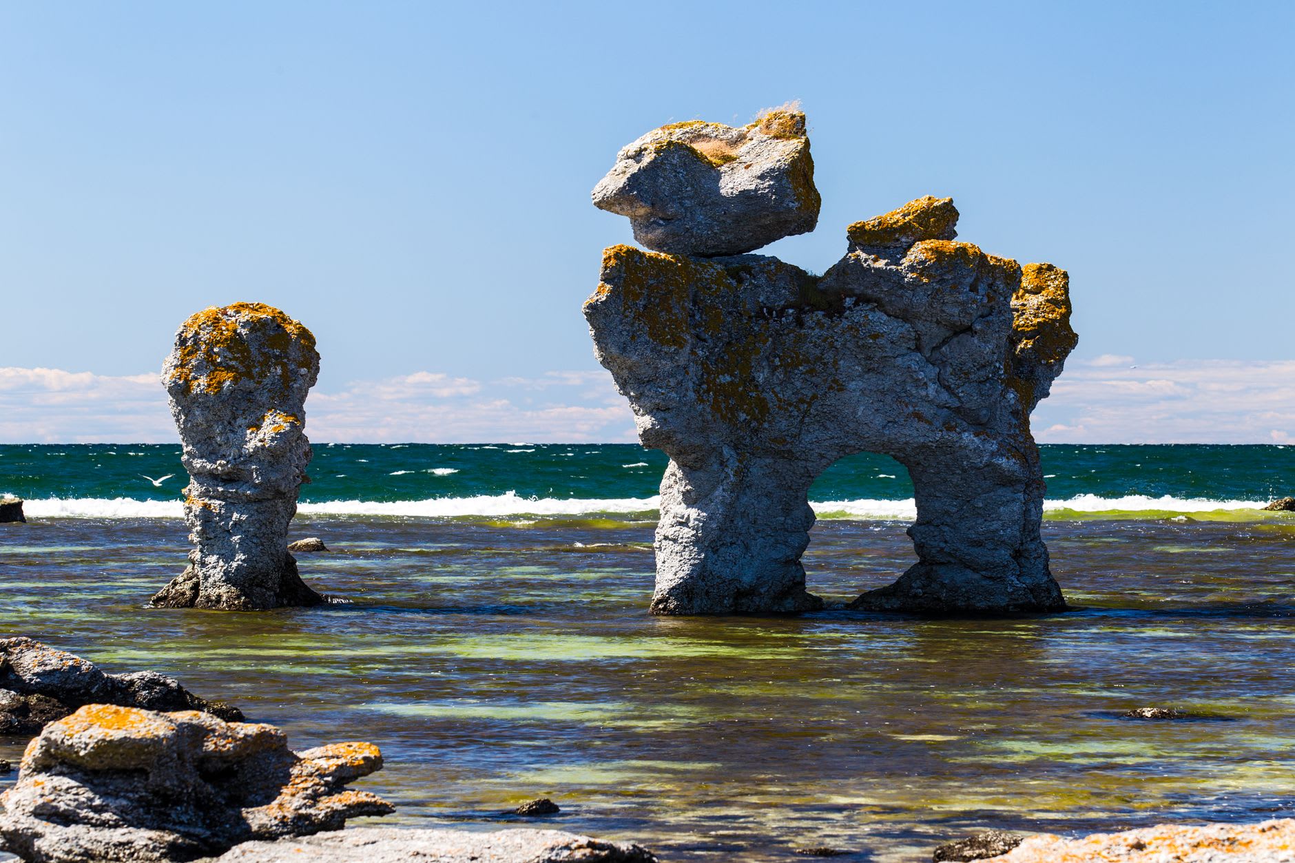 Pilares de piedra caliza raukar alzándose en el Báltico poco profundo de Ljugarn bajo la luz dorada de la tarde