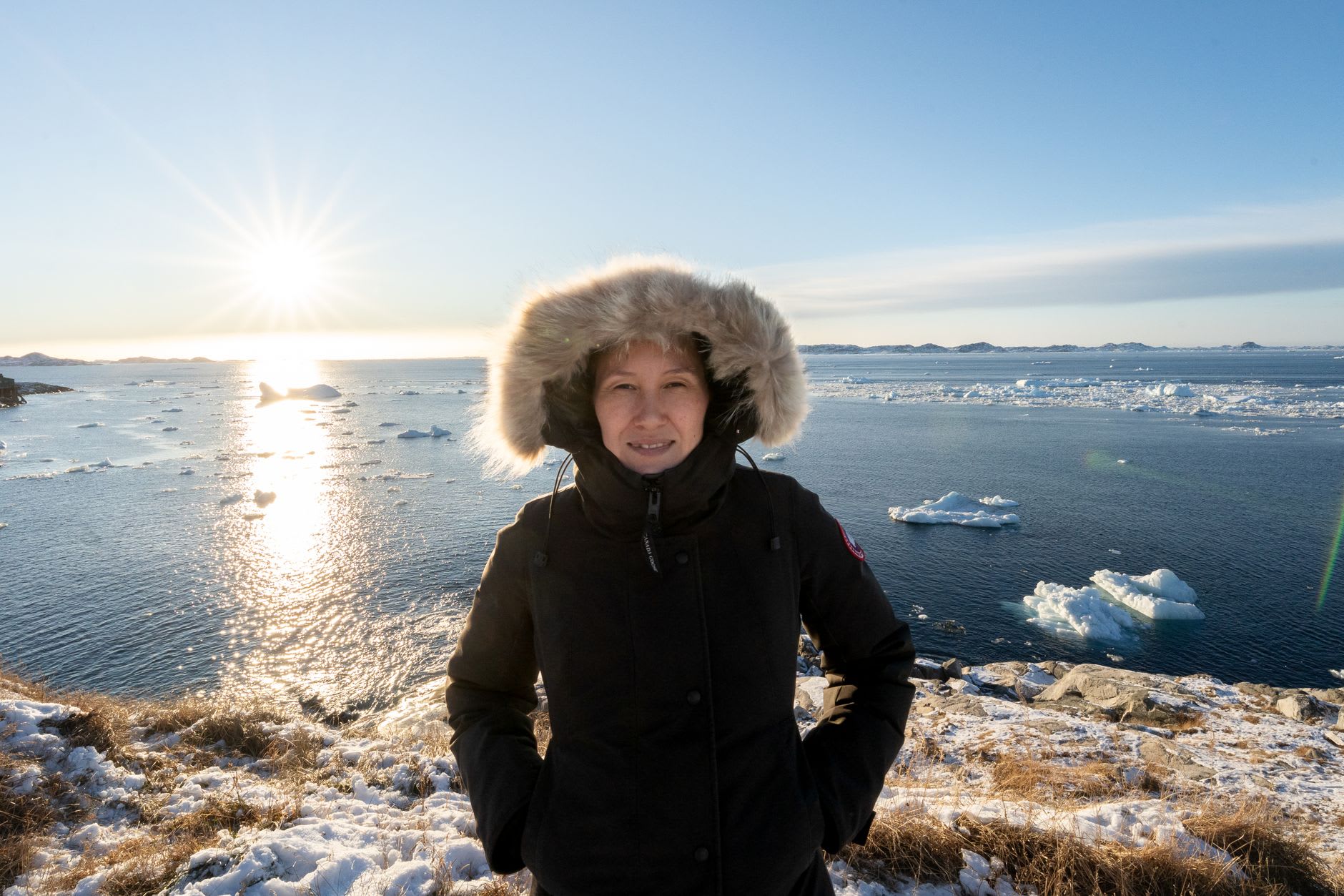 Midnight sun casting golden light over the floating icebergs of Disko Bay viewed from Ilulissat waterfront