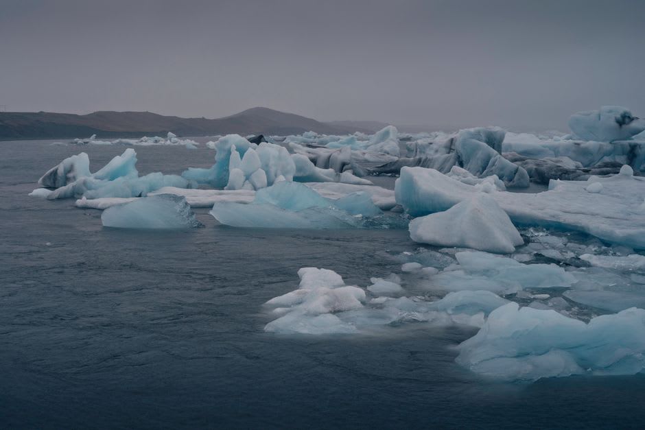 Sol de medianoche sobre icebergs a la deriva en la bahía de Disko, vistos desde el puerto de Qeqertarsuaq
