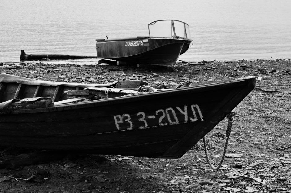 Small fishing boats resting on the black sand beach at Pointe-Noire harbor
