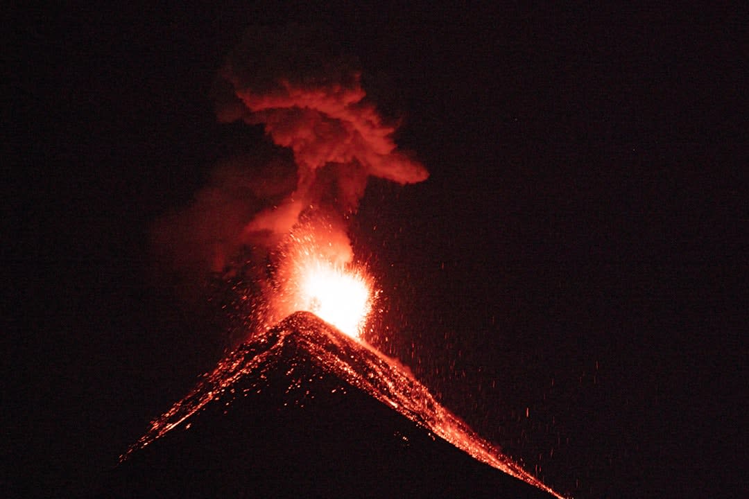 Volcán de Fuego erupting with glowing lava visible against the night sky