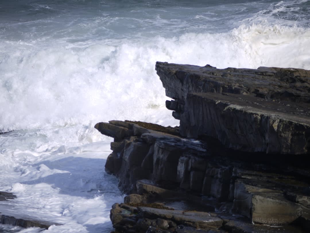 The rusted iron ruins of Champerico's historic pier extending into the Pacific surf