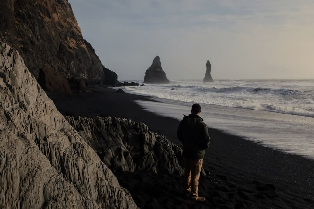 Fishermen sorting the day's catch on the black-sand beach as boats return at midday
