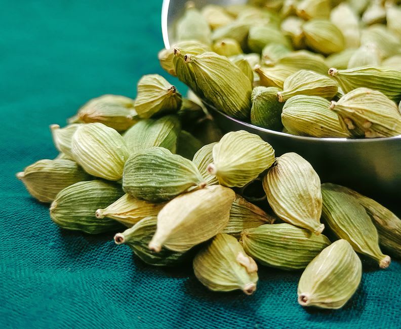Sacks of green cardamom pods piled at a Cobán market stall