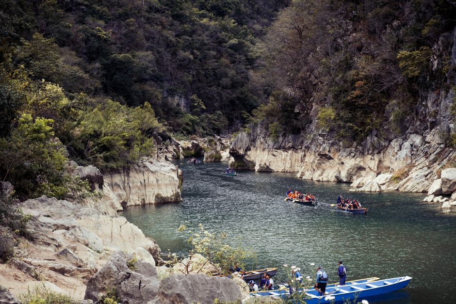 Wooden cayuco canoe drifting through the narrow limestone gorge