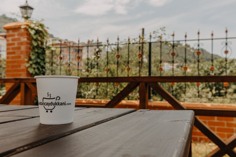 A cupping table set up on a terrace at Finca Filadelfia with small bowls of roasted coffee and Volcán de Agua visible in the hazy distance