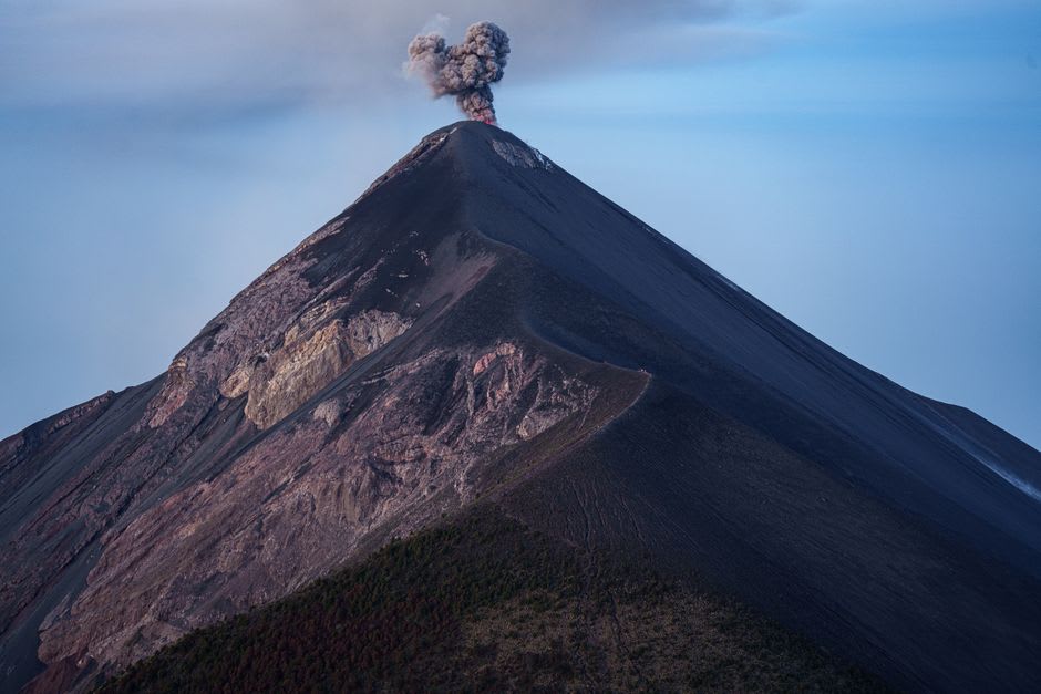 Volcán de Fuego venting smoke above green highland terrain near Antigua